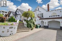 White stucco exterior with an attached garage and arched entryways - 