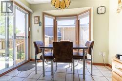Tiled flooring extending to a bay window and sliding glass door - 