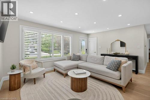 Bright living area featuring light wood-finish flooring, recessed lighting, and white plantation shutters - 603 Cornick Drive, Burlington, ON 