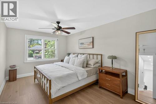 Light-filled room featuring wood-finish flooring, a window with white louvered shutters, and a ceiling fan with integrated lighting - 603 Cornick Drive, Burlington, ON 