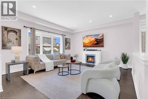 Spacious living area featuring dark wood-finish flooring, a white fireplace with a mantel, and recessed ceiling lighting - 92 Desoto Drive, Hamilton, ON - Indoor Photo Showing Living Room With Fireplace