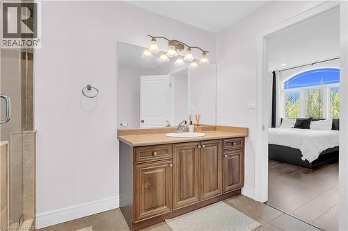 Bathroom vanity with a single basin sink, light-toned countertop, and wood-finish cabinetry - 92 Desoto Drive, Hamilton, ON - Indoor Photo Showing Bathroom
