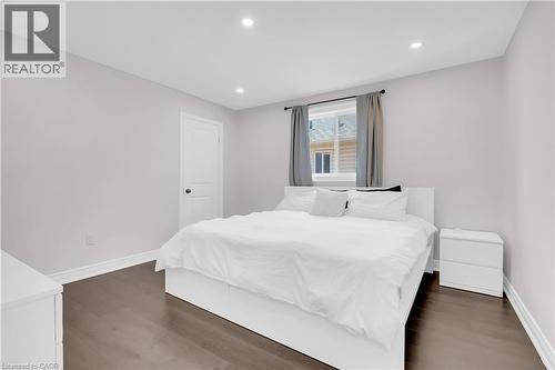 Spacious bedroom featuring wood-finish flooring, recessed lighting, and a window with a curtain rod - 92 Desoto Drive, Hamilton, ON - Indoor Photo Showing Bedroom