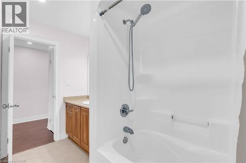 White bath and shower combination with a handheld showerhead and built-in shelving - 92 Desoto Drive, Hamilton, ON - Indoor Photo Showing Bathroom