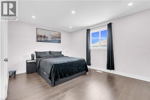 Spacious bedroom featuring wood-finish flooring, a large window with black drapery, and recessed lighting - 92 Desoto Drive, Hamilton, ON - Indoor Photo Showing Bedroom