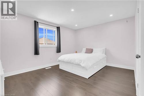 Bedroom featuring wood-finish flooring, recessed lighting, and a window with white trim - 92 Desoto Drive, Hamilton, ON - Indoor Photo Showing Bedroom