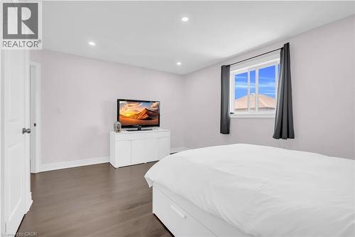 Bedroom featuring wood-finish flooring, recessed lighting, and a window with dark drapery - 92 Desoto Drive, Hamilton, ON - Indoor Photo Showing Bedroom