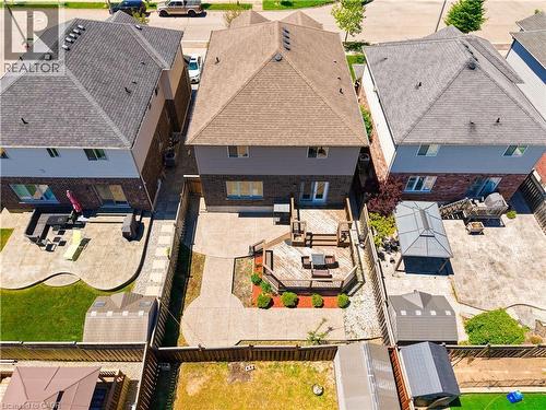 Rear exterior featuring a multi-level wood deck, concrete patio, and garden beds - 92 Desoto Drive, Hamilton, ON - Outdoor