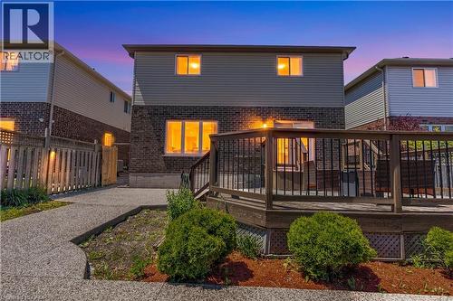 Rear exterior featuring a spacious wood deck with black metal balusters, a sliding glass door, and multiple windows - 92 Desoto Drive, Hamilton, ON - Outdoor With Deck Patio Veranda With Exterior