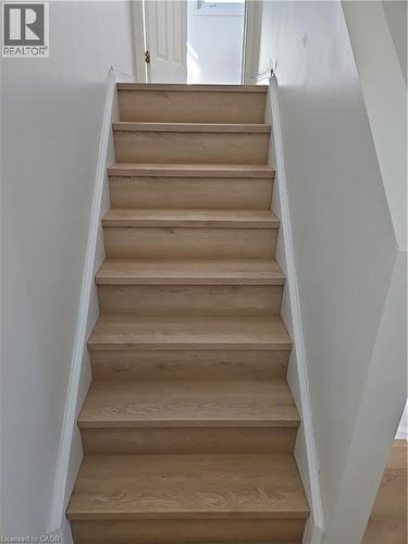 Staircase featuring wood-finish treads and risers with white painted stringers - 390 Wake Robin Crescent, Kitchener, ON - Indoor Photo Showing Other Room