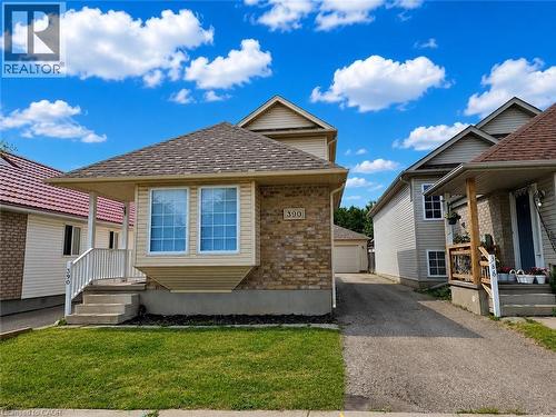 Exterior featuring a brick facade with light-toned siding, a bay window, and a shingled roof - 390 Wake Robin Crescent, Kitchener, ON - Outdoor