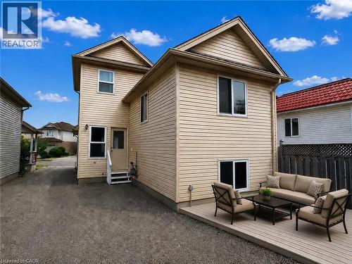 Rear exterior featuring light-colored siding and multiple windows - 390 Wake Robin Crescent, Kitchener, ON - Outdoor With Exterior