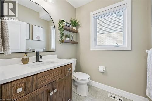 Bathroom featuring a wood-finish vanity with ample storage, a white countertop, and a rectangular undermount sink - 30 Waterbow Trail, Kitchener, ON - Indoor Photo Showing Bathroom