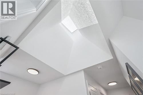 Vaulted ceiling with an integrated skylight, recessed lighting, crown molding, and contemporary wall decor - 30 Waterbow Trail, Kitchener, ON - Indoor Photo Showing Other Room