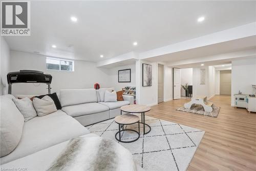 Spacious lower-level living area featuring recessed lighting, light wood-finish flooring, and white walls - 30 Waterbow Trail, Kitchener, ON - Indoor Photo Showing Basement