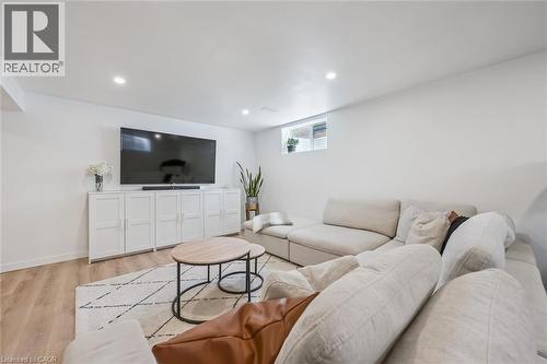 Spacious room featuring light-toned wood-finish flooring, recessed lighting, and a window - 30 Waterbow Trail, Kitchener, ON - Indoor Photo Showing Living Room