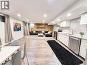 Open-concept living space featuring wood-finish flooring, recessed lighting, and a kitchen area with white cabinetry, stainless steel appliances, and a light-toned countertop - 11 Duncairn Avenue, Kitchener, ON  - Indoor Photo Showing Kitchen 