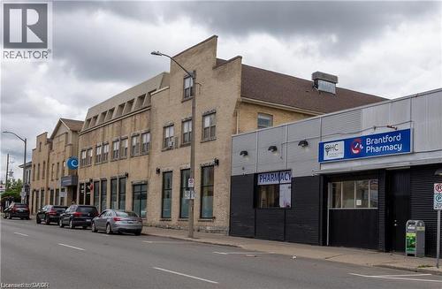 Commercial building featuring a brick facade with a stepped parapet roofline - 365 Colborne Street, Brantford, ON 