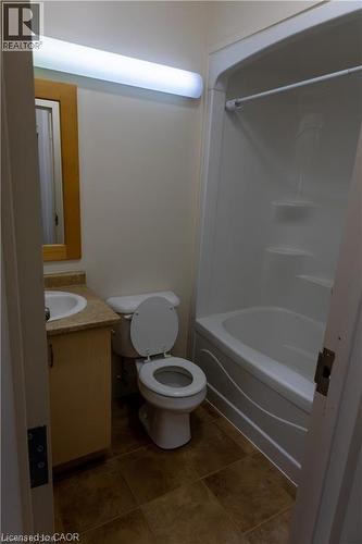 Bathroom featuring a white bathtub and shower combination, a white toilet, and a vanity with a light-colored countertop - 365 Colborne Street, Brantford, ON 