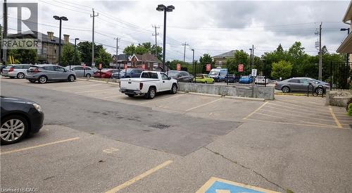 Paved parking lot with marked spaces, security fencing, and exterior lighting fixtures - 365 Colborne Street, Brantford, ON 