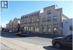 Multi-story brick facade building featuring ground-level commercial window frontage, multiple upper-story windows, and a street-facing entryway - 