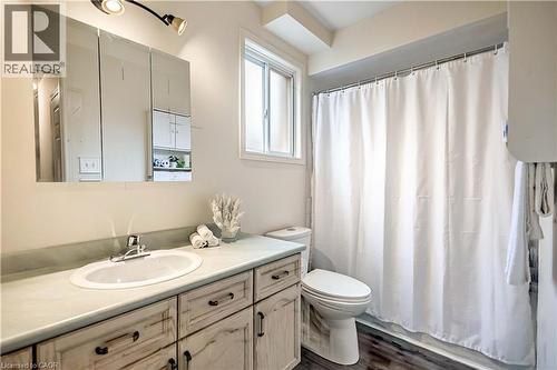 Bathroom featuring a vanity with a white oval sink, a light-toned countertop, and distressed-finish cabinetry - 640 Acadia Drive, Hamilton, ON 