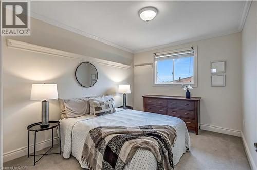 Bedroom featuring neutral wall paint, white crown molding, light gray carpeting, and a window with blinds - 640 Acadia Drive, Hamilton, ON 