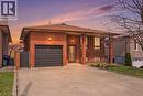 Brick exterior featuring a private driveway, attached garage, covered entryway, and mature landscaping - 957 Stone Church Road E, Hamilton, ON  - Outdoor 