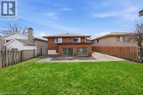 Expansive green lawn with a concrete patio - 957 Stone Church Road E, Hamilton, ON - Outdoor