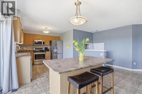 Kitchen featuring a central island with seating, stainless steel appliances, light wood-finish cabinetry, and tiled flooring - 136 Carpenter Road, Cambridge, ON - Indoor Photo Showing Kitchen With Double Sink