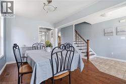 Dining area featuring wood-finish flooring, a pass-through window, and a flush mount ceiling light - 