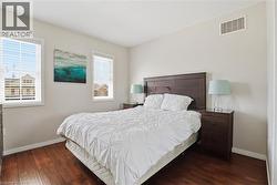 Bedroom featuring rich wood-finish flooring and light-toned walls - 