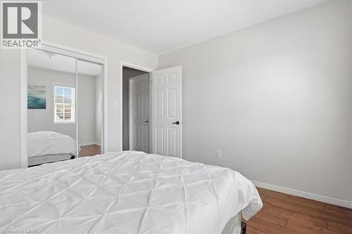 Bedroom featuring wood-finish flooring, a full-lite interior door, and a mirrored closet with sliding doors - 136 Carpenter Road, Cambridge, ON - Indoor Photo Showing Bedroom