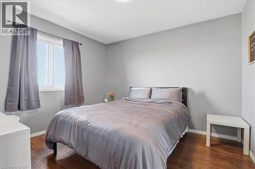 Bedroom featuring wood-finish flooring, light gray walls, a window with white trim, and a textured white ceiling - 136 Carpenter Road, Cambridge, ON - Indoor Photo Showing Bedroom