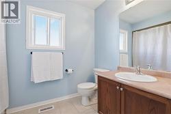 Bathroom featuring a single window, a wood-finish vanity with an integrated sink, a single-handle faucet, a wall-mounted mirror, and tile flooring - 