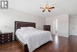 Spacious room featuring wood-finish flooring, a ceiling fan, and light-colored walls - 