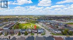 Aerial perspective showcasing a residential neighborhood with detached homes, green spaces, and tree-lined streets - 