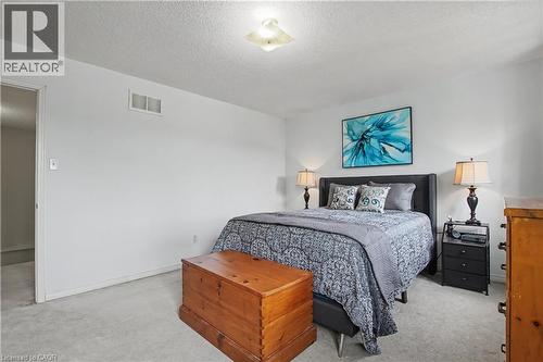 Carpeted bedroom featuring a flush-mount ceiling light, white walls, and a visible doorway - 236 Fitzgerald Crescent, Milton, ON - Indoor Photo Showing Bedroom