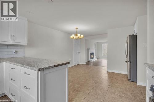 Open-concept kitchen featuring white cabinetry, granite-finish countertops, subway tile backsplash, and stainless steel appliances - 22 Blackhorne Crescent, Kitchener, ON - Indoor Photo Showing Kitchen