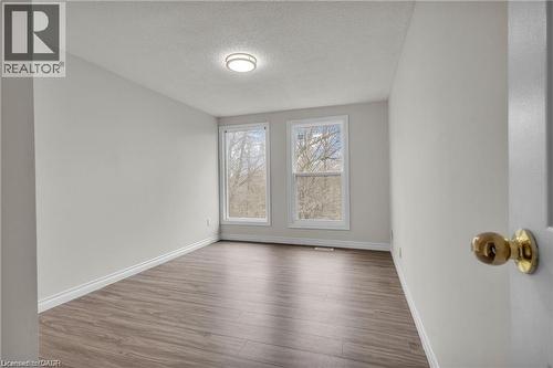 Room featuring two double-hung windows, wood-finish flooring, light grey walls, and a recessed ceiling light fixture - 22 Blackhorne Crescent, Kitchener, ON - Indoor Photo Showing Other Room