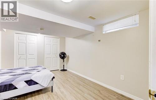 Room featuring wood-finish flooring, light-toned walls, and a ceiling-mounted light fixture - 22 Blackhorne Crescent, Kitchener, ON - Indoor Photo Showing Bedroom