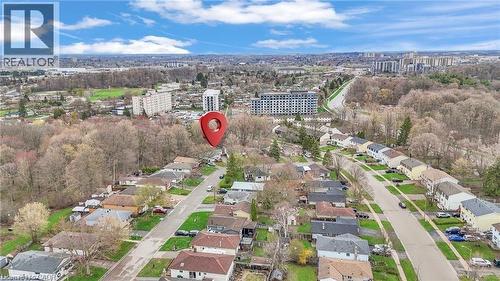 Aerial perspective highlighting a residential street lined with single-story homes, surrounded by mature trees - 22 Blackhorne Crescent, Kitchener, ON - Outdoor With View