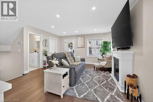 Open-concept living space with wood-finish flooring, recessed lighting, and a white fireplace - 109 Ray Street N, Hamilton, ON - Indoor