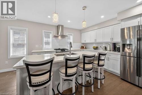 Contemporary kitchen featuring white shaker cabinetry and a central island with countertop seating - 109 Ray Street N, Hamilton, ON - Indoor
