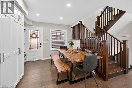 Open-concept dining area featuring wood-finish flooring, recessed lighting, and a prominent wood staircase with matching balusters - 109 Ray Street N, Hamilton, ON - Indoor Photo Showing Other Room