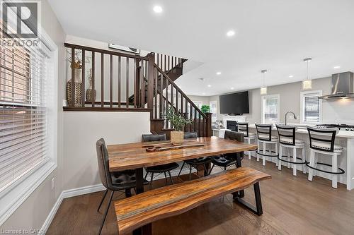 Open-concept living area featuring wood-finish flooring, recessed lighting, and a prominent staircase with dark wood balusters - 109 Ray Street N, Hamilton, ON - Indoor Photo Showing Other Room