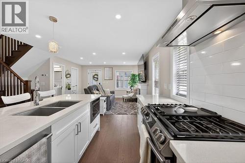 Modern kitchen featuring white cabinetry, light countertops, and a dual basin undermount sink - 109 Ray Street N, Hamilton, ON - Indoor Photo Showing Kitchen With Double Sink With Upgraded Kitchen