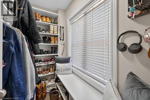 Built-in closet system featuring multiple shelves and hanging rods, complemented by a window with white blinds and a built-in bench - 109 Ray Street N, Hamilton, ON - Indoor With Storage