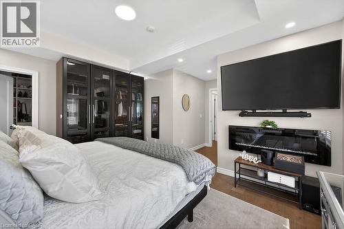 Recessed lighting illuminates the tray ceiling and wood-finish flooring - 109 Ray Street N, Hamilton, ON - Indoor Photo Showing Bedroom