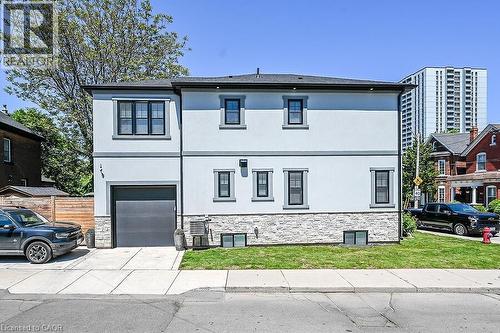 Contemporary facade featuring light-colored stucco and a stone-clad foundation - 109 Ray Street N, Hamilton, ON - Outdoor With Facade